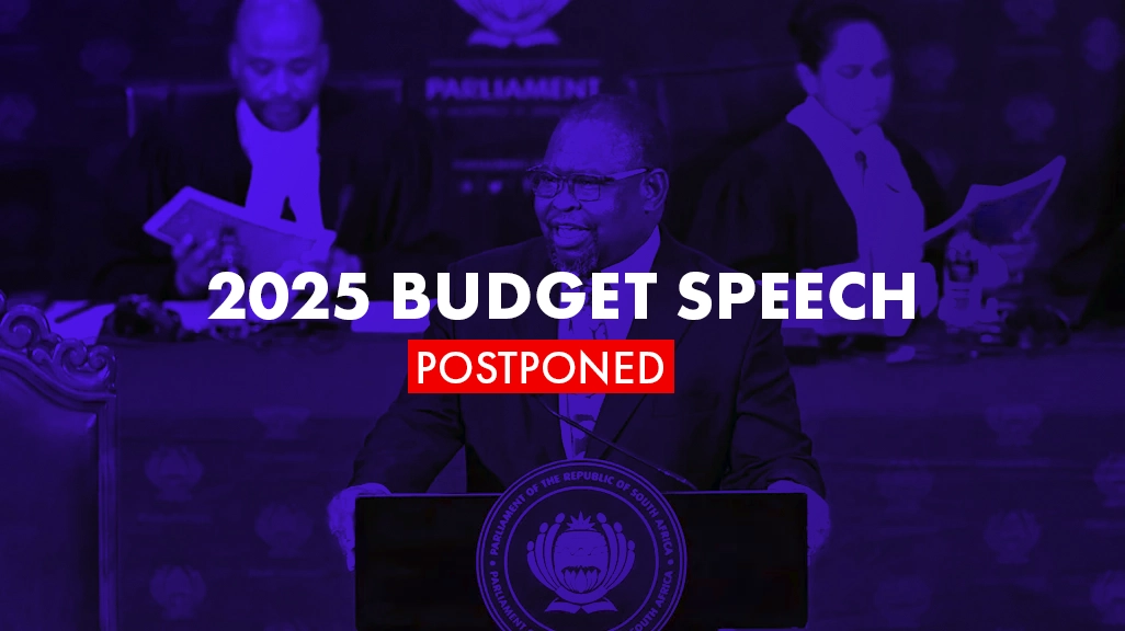 Blue overlay of South Africa’s Finance Minister, Enoch Godongwana, standing on a podium. The image has the text 2025 budget speech postponed